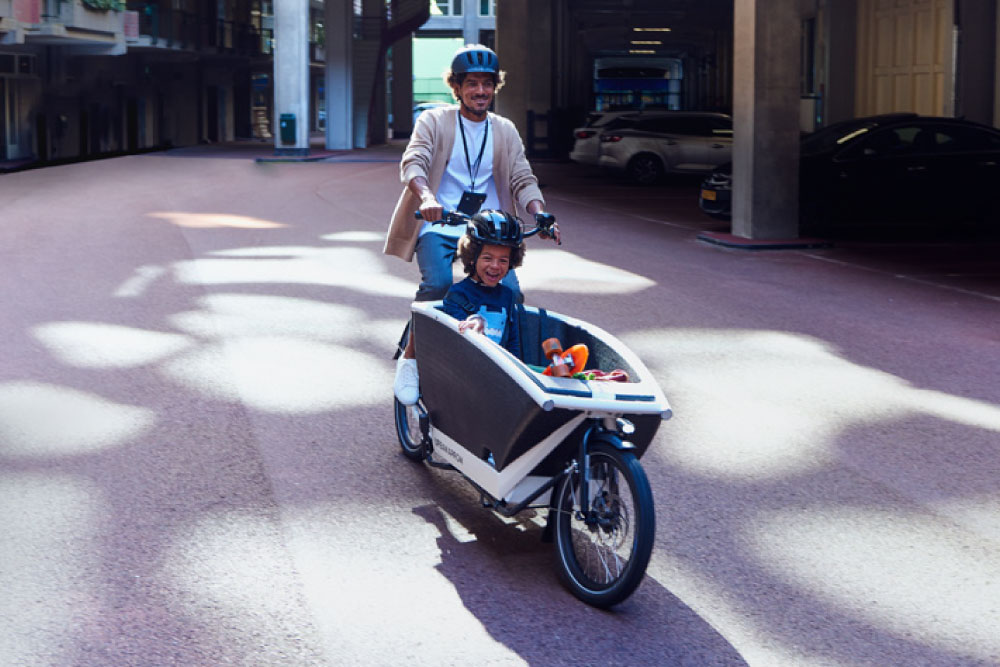 Ein Mann fährt mit seinem Kind im Urban Arrow Cargobike